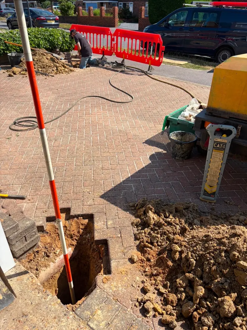 Howard of Grange Plumbing carrying out a moling operation on a residential driveway in Surrey