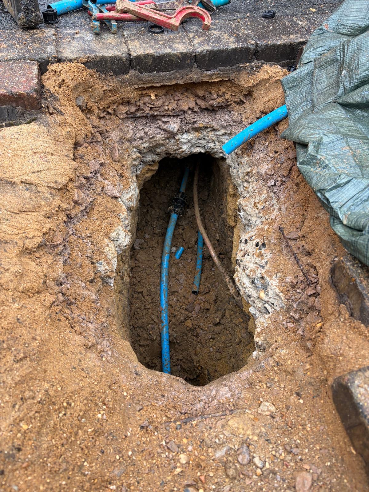Underground water main replacement beneath block paving in East Grinstead, showing the new pipe route.