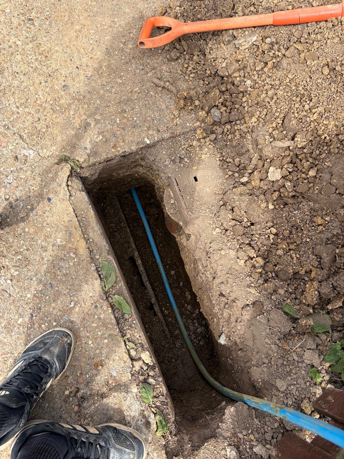 Trenchless moling access pit in gravel driveway — Grange Plumbing Sussex