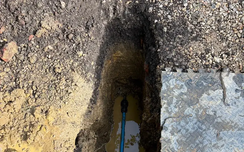 New blue MDPE water pipe installed in a small moling access pit at a Sussex property