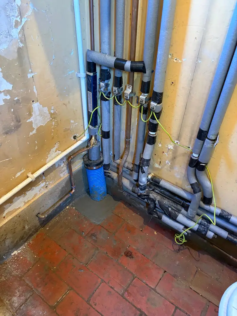 Internal pipework and blue duct at the water supply entry.