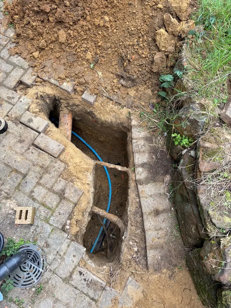 Blue water supply pipe installed beneath lifted block paving in Oxted.